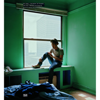 The cover of a book titled The City / Becoming and Decaying, showing a young man in a fedora sitting pensively on a wide windowsill in a room with vibrant green walls. He is illuminated by the light from the window, which looks out onto a modern skyscraper. An unmade bed is in the foreground.