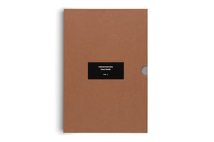 A light brown cardboard book slipcase, shot from above against a white background. A black label in the center reads in white text: FREQUENCIES, Oscar Murillo, VOL. I. On the right edge, a small semi-circular notch is cut out.