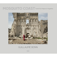 The book cover for Mosquito Coast: Travels from Maputo to Mogadishu by Guillaume Bonn. The central photograph shows a person in a bright red robe walking up the rubble-strewn steps of a large, ruined stone building with Gothic arches.