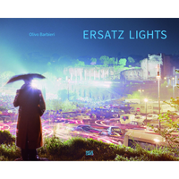 The book cover for Ersatz Lights by Olivo Barbieri, featuring a hazy, long-exposure photograph of a city at night. A person in a dark coat stands in silhouette holding an umbrella, overlooking streets filled with the glowing pink and white light trails of moving cars. In the distance, ancient ruins are brightly lit against a dark blue sky.