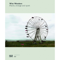 The book cover for Wim Wenders' Places, strange and quiet, showing a solitary Ferris wheel in an empty field under a cloudy sky.
