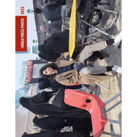 The World Press Photo 2023 cover shows a woman in a tan coat looking directly at the camera, seated at an outdoor table amidst a crowd that includes women in black chadors.