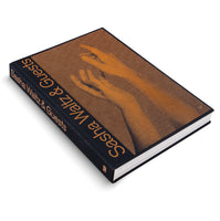 An angled shot of a black hardcover book titled Sasha Waltz & Guests against a white background. The title is in a sans-serif orange font. The cover features a large, orange halftone graphic of two hands reaching towards each other.