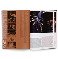 An open art book displaying a two-page spread about contemporary dance. The left page, marked with the year 2010, contains columns of text and several small black-and-white photos of dancers. The right page features a large, dynamic color photograph of a dance performance with several dancers in motion on a dark stage.