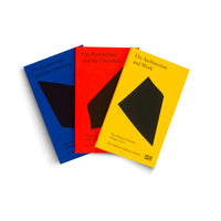 Three paperback books with minimalist covers in blue, red, and yellow are fanned out against a white background. Each cover features a large, irregular black shape and white text. The titles are On Architecture and Greenwashing, On Architecture and the Greenfield, and On Architecture and Work.