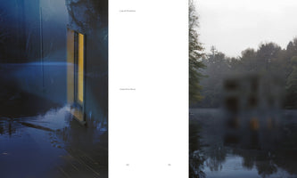 A two-page photo book spread for Liquid Shadows by Valentina Noce. On the left, a dark, blue-toned image shows a partially submerged building at night, a long yellow window reflecting on the water. On the right, a blurry building sits by a lake on a foggy day, surrounded by trees.