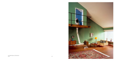 A two-page book spread. The right page features a photograph of a living room with green walls and mid-century furniture. A wooden loft overlooks the room, and on it, a toilet is visible inside a blue-tiled doorway. A large, white, flexible pipe runs from under the loft down to a vintage television set on the floor below. The facing left page is white and has the text Live-Übertragung | Live Broadcast.