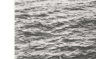 A hyperrealistic black and white graphite drawing of a choppy sea viewed from above. The entire frame is filled with the intricate, textured detail of countless small waves and ripples, with highlights and shadows creating a strong sense of depth and movement. A white border is visible on the left edge.