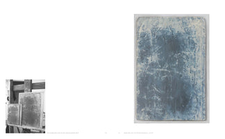 A two-page spread from an art book. On the left, a small black and white photo shows two abstract canvases on an easel in a studio. On the right, a large color image displays one of the artworks in detail: a vertical abstract painting with a highly textured surface, featuring mottled patterns of deep blue and creamy white that evoke a sense of weathered stone or ice.