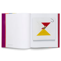 An open art book is laid flat, showing a two-page spread. The left page is mostly blank with a small caption in the bottom corner. The right page displays a color reproduction of an abstract geometric painting featuring a red and a yellow triangle forming an hourglass shape against a white background.