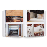 A photograph of an open book displaying a two-page spread with four color photos. On the left page, a tour bus for the AlUla Future Culture Summit is parked in front of a rock face, and below it is a photo of an ATM in a wall niche. The right page shows two photos of interior spaces under construction, one empty and the other with two ladders and exposed framework.